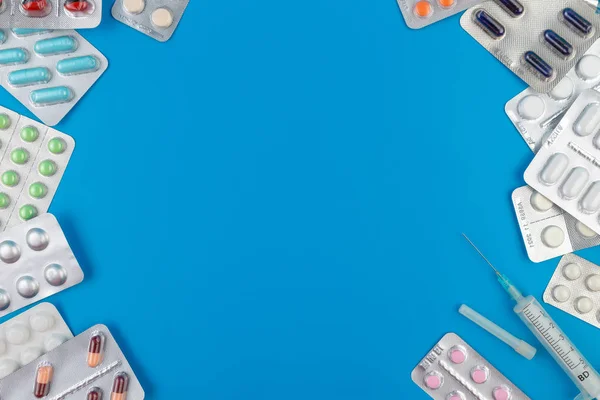 Barevné tabletky a tablety na modrém pozadí s prostorem pro kopírování — Stock fotografie
