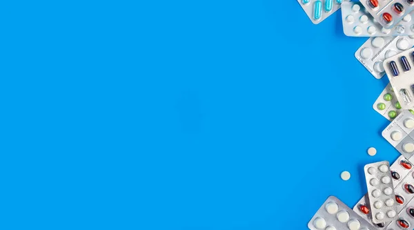Farbige Pillen und Tabletten auf blauem Hintergrund mit Kopierraum — Stockfoto