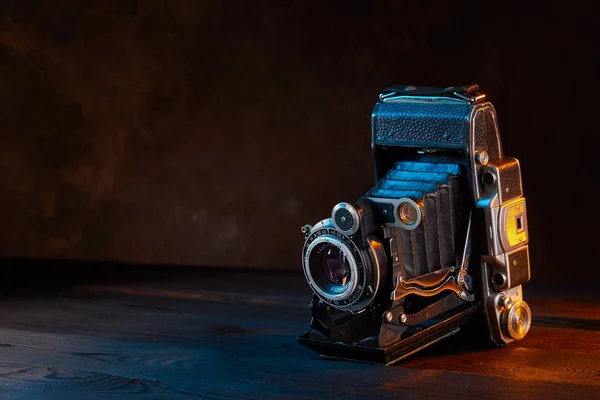 Vecchia fotocamera vintage sul tavolo di legno. Stile cinematografico . — Foto Stock