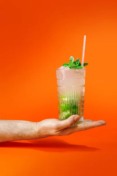 Close Man Hand Holding Glass Tropical Mojito Cocktail Orange Background — Stock Photo, Image