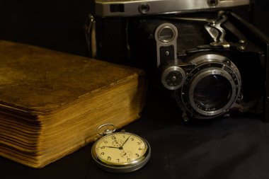 Eski kamera ve eski cep saati eski lens eski kitap