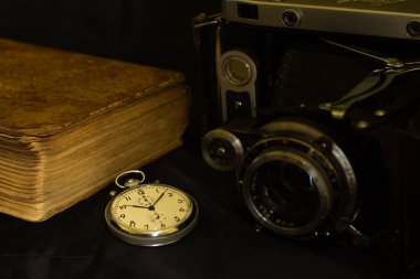 Eski kamera ve eski cep saati eski lens eski kitap