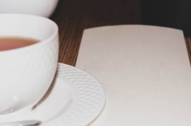 beyaz fincanın seçici odak noktası ve boş kağıt masa üzerinde kopyalama alanı