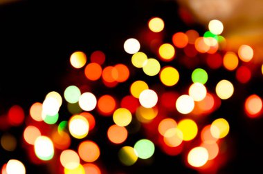 Odaklanamayan, parlak, koyu arkaplanda bulanık ışıklar.