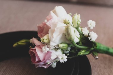 Damat yaka çiçeğinin seçici odağı. Damat kemerinde pembe ve beyaz güller.