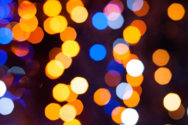 Duvar kağıdı ve tasarım için bokeh etkisi ile koyu bulanık arkaplan üzerinde parlak ve odaksız renkli ışıklar