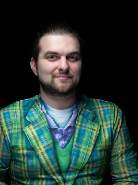 Yakışıklı, ciddi, sakallı, yeşil ekose ceketli adam, siyah üzerine izole edilmiş kameraya bakıyor.