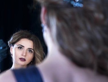 Güzel bir kadının fotoğraf stüdyosundaki yansımasına baktığı yumuşak bir odak noktası.