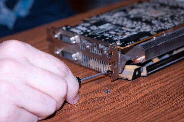 cropped view of master disassemble graphics card for computer on wooden surface in home improvement