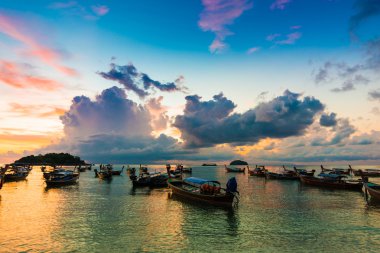 Andaman Denizi'nde gündoğumu sırasında yanan gökyüzü ile ahşap tekne yansıma