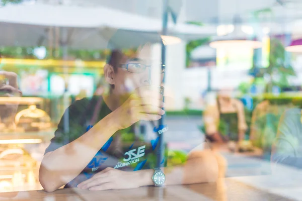 Азиатские Мужчины Пьют Кофе Глядя Сторону Кафе Через Стекло — стоковое фото