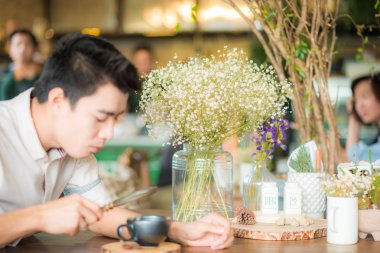 Bir kahve dükkanında okuyan erkekler