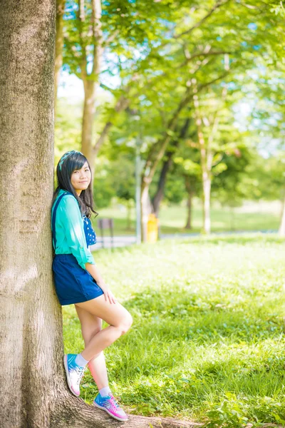 Asiática linda mujer relajante y disfrutando bajo el árbol —  Fotos de Stock