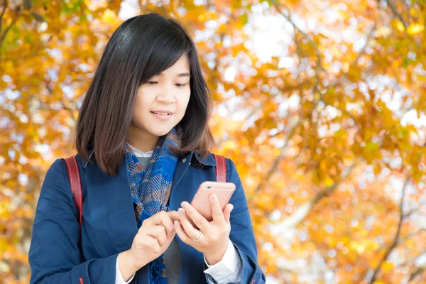 Счастливая молодая женщина разговаривает по мобильному телефону стенд на осенний парк — стоковое фото
