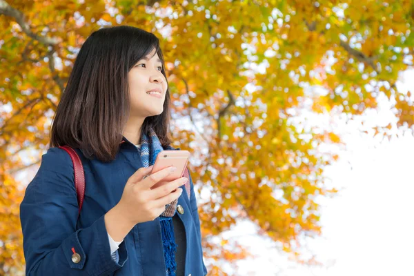 Szczęśliwa młoda kobieta rozmowy na telefon komórkowy stojak na jesień park — Zdjęcie stockowe