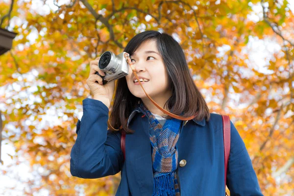 Fotógrafo de viajes en el trabajo en otoño hojas coloridas de árboles — Foto de Stock