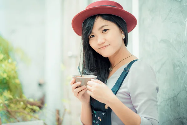 Asian cute women holding coffee cup on  art wall — Stock Photo, Image
