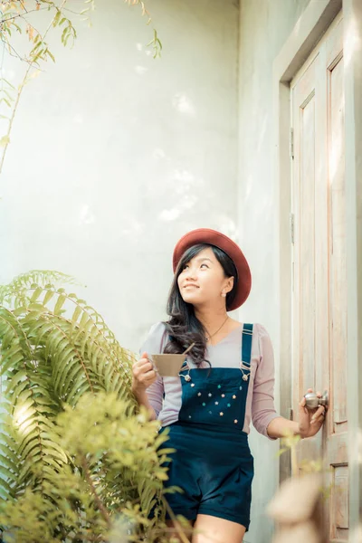 Asiatico carino donne holding caffè tazza su arte parete — Foto Stock