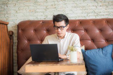 Genç gözlük işadamı sittin kafede dizüstü bilgisayar ile çalışma 