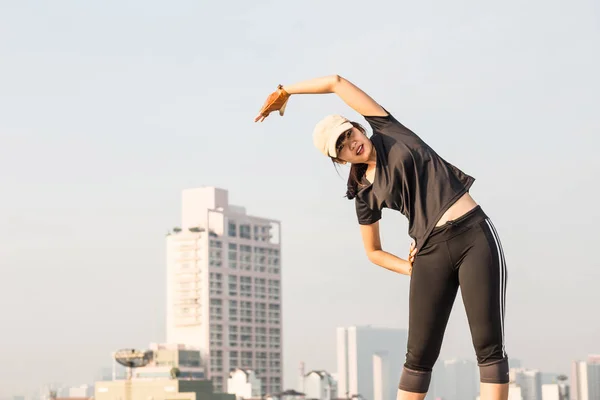 微笑运动亚洲女人拉伸为建筑 顶部健身锻炼的妇女 — 图库照片