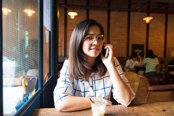 女人坐在阁楼的咖啡馆使用移动电话业务的连接 — 图库照片