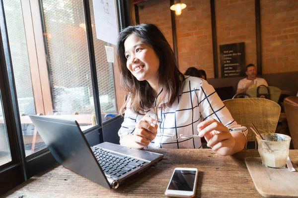 Imagen de cerca de la joven mujer que trabaja en el ordenador portátil mientras está sentada — Foto de Stock