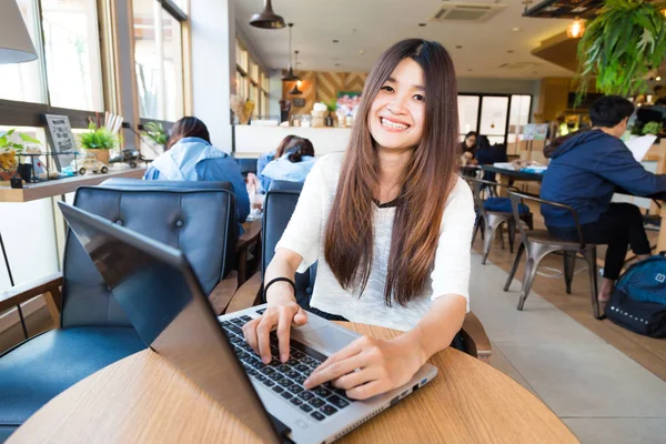 Sonriente asiática estudiante mujer casual navegación el internet — Foto de Stock