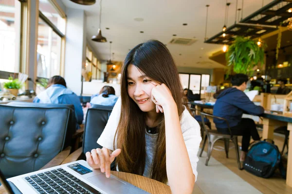 Joven estudiante inteligente aprendiendo en el ordenador portátil en la biblioteca — Foto de Stock