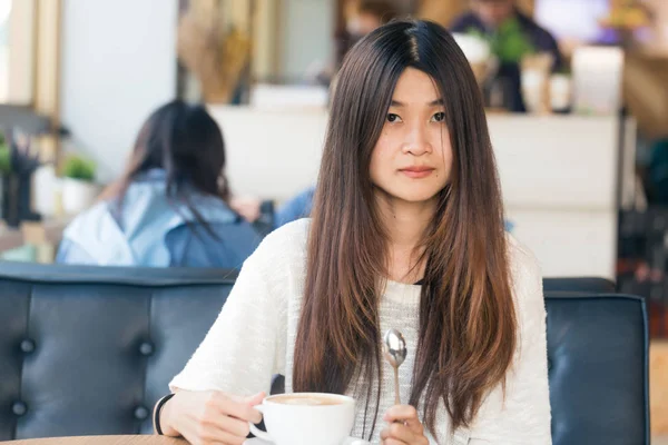 Feliz asiático hembra con café con leche en la cafetería durante el tiempo libre —  Fotos de Stock