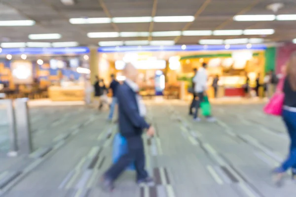 Passageiro desfocado no corredor do aeroporto com viajantes ambulantes — Fotografia de Stock