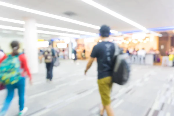 Passageiro desfocado no corredor do aeroporto com viajantes ambulantes — Fotografia de Stock