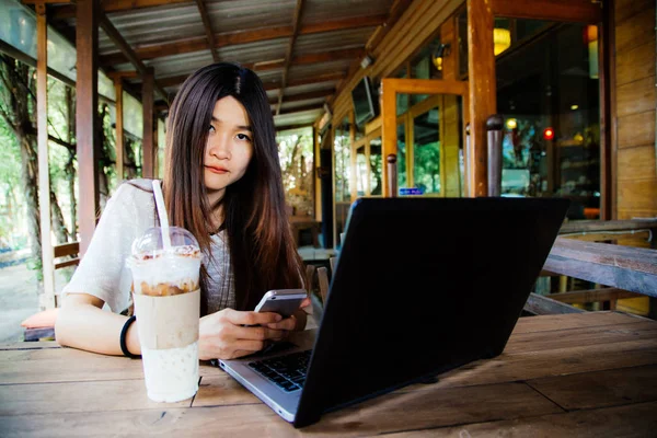 Mujer de negocios que utiliza ordenador portátil portátil con comunicados telefónicos — Foto de Stock