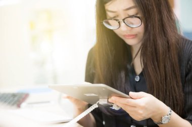 Öğrenme Kütüphanesi'nde için dijital tablet kullanarak kadın genç ofis