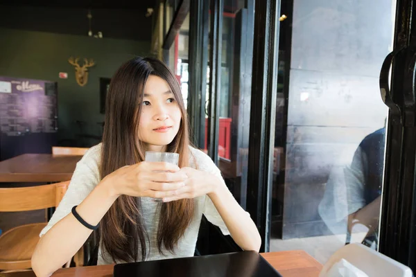 Ευτυχισμένος χαμογελαστό γυναίκα λειτουργεί με laptop και πίνοντας κρύα latte — Φωτογραφία Αρχείου