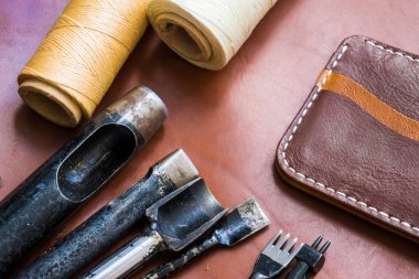 Deri el sanatları için cüzdan deri craftman'ın çalışma masası üzerinde aracı ile çalışma .