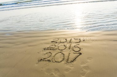 Yeni yıl sahil dalga ile gündoğumu, kum üzerinde yazılı 2017