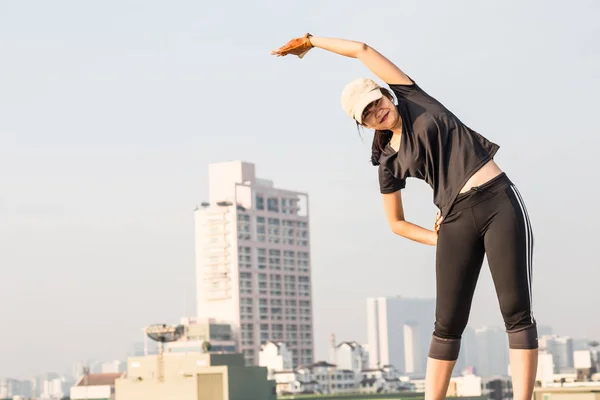 亚洲妇女健身日出舒展在慢跑锻炼之前健康概念大厦背景 — 图库照片