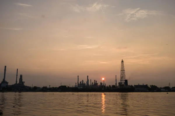 Oil refinery construction plant sunrise with river