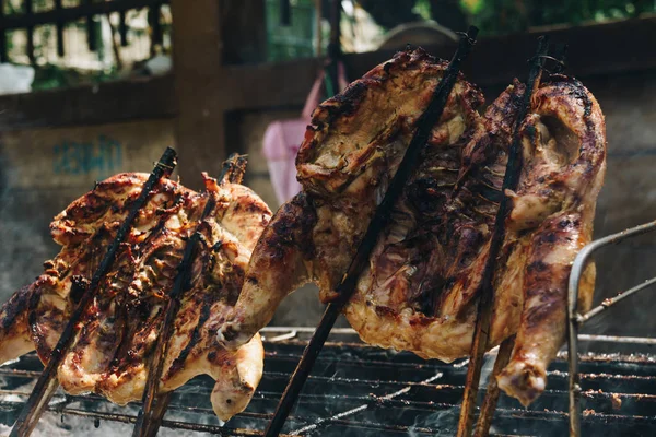 Chicken grilled on fire outdoor traditional asian food with herb