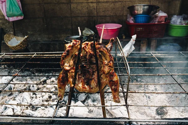 Chicken grilled on fire outdoor traditional asian food with herb