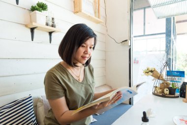 Genç öğrenci kadın içme kahve ve kitap okumak, eğitim iş kavramı Café