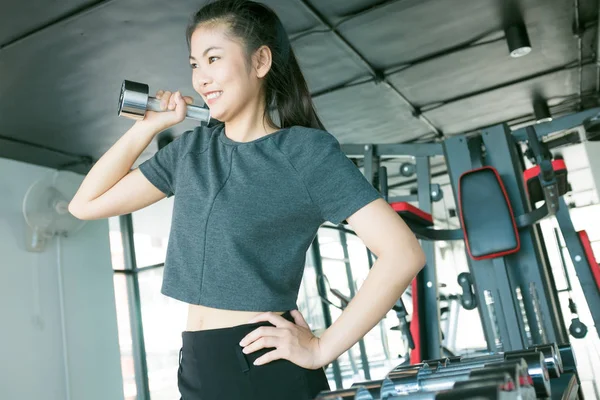 Mujeres haciendo ejercicio con pesas de metal en el gimnasio moderno —  Fotos de Stock
