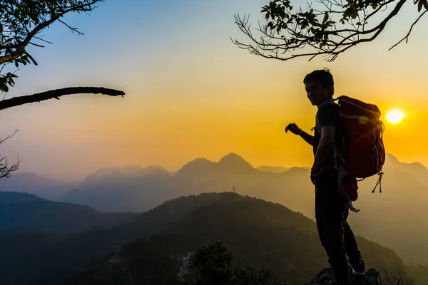 Senderismo hombre de pie en la colina disfrutando de la puesta del sol — Foto de Stock