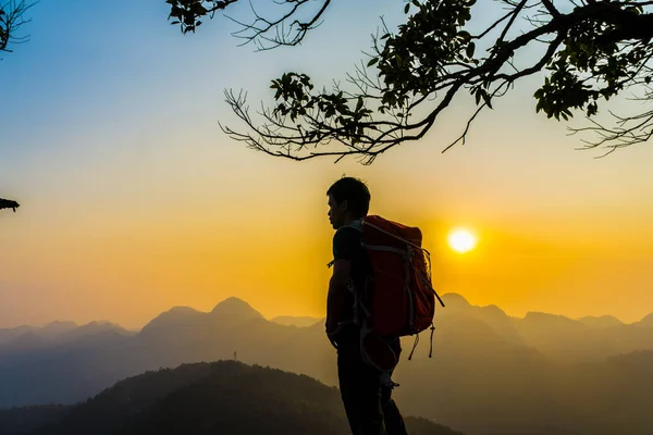 Senderismo hombre de pie en la colina disfrutando de la puesta del sol — Foto de Stock