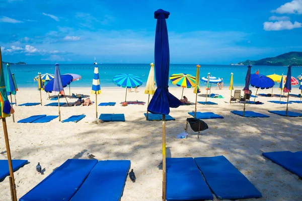 Playa de mar con gente relajada y colorida de sombrilla — Foto de Stock