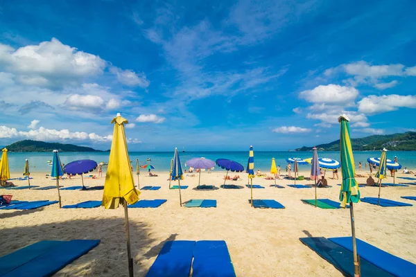 Playa de mar con gente relajada y colorida de sombrilla — Foto de Stock
