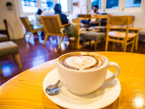 Café de arte latte sobre mesa de madera — Foto de Stock