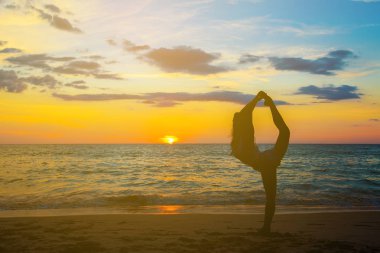 Yoga duruş deniz sahilde kadınla siluet 