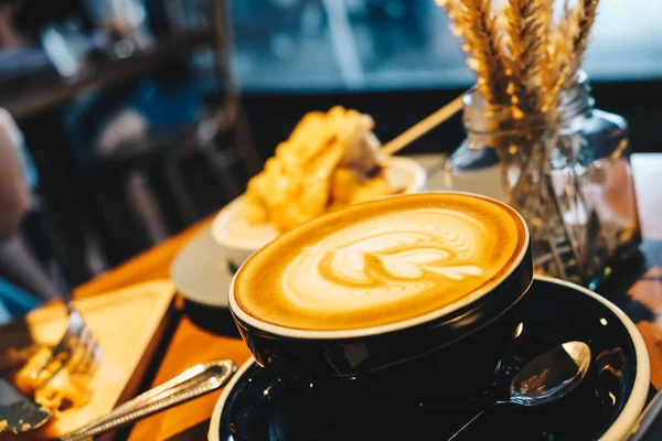 Cangkir seni latte panas di meja kayu — Stok Foto
