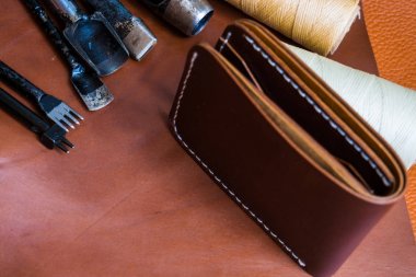 DIY deri bifold cüzdan el sanatları ile aracı nesne üzerinde kahverengi deri arka plan